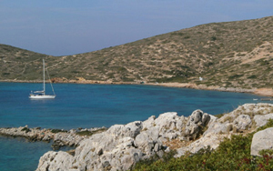 Foto panoramica di isola greca con barca a vela nel golfo.